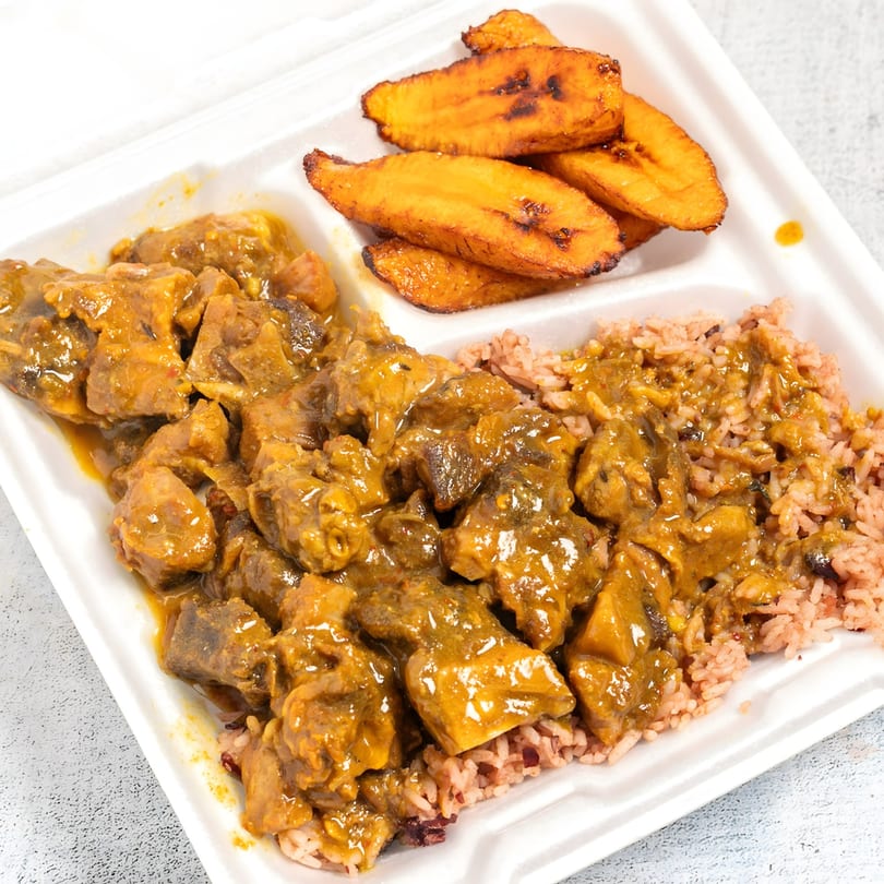Top Taste Grill's Jamaican curry goat with rice and peas, and fried plantains in a takeout container.